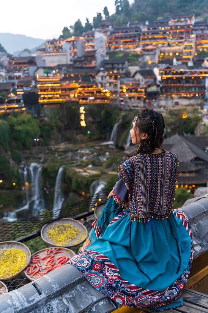 Mujer observa el atardecer en la ciudad Lijijang