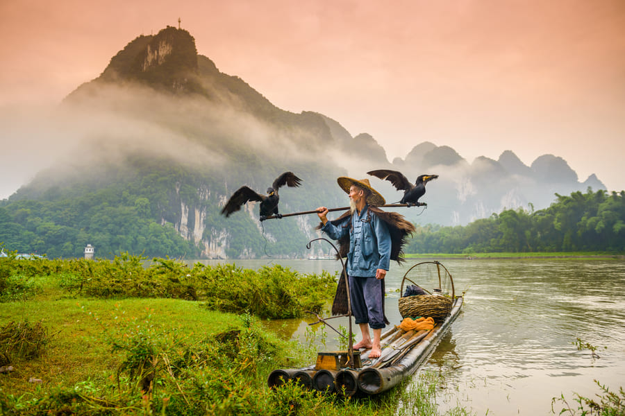 Hombre pescador de Yangshuo en el lago.
